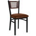 A BFM Seating black metal side chair with a walnut wooden back and light brown vinyl seat.