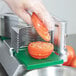 A person using a Garde tomato slicer to cut a tomato.