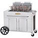 A large stainless steel cart with two baskets for frying on a Crown Verity PF-2-NG outdoor fryer.
