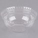 A clear plastic dome lid with a decorative edge on top of a clear bowl.