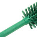 A Carlisle Sparta Spectrum green bottle cleaning brush with bristles.