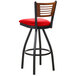 A BFM Seating black metal bar stool with a red vinyl seat and cherry wood back.