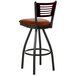 A BFM Seating metal bar stool with a light brown vinyl swivel seat and mahogany wooden back.