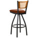 A BFM Seating black metal bar stool with a light brown vinyl swivel seat and a natural wood back.