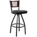 A BFM Seating black metal bar stool with a wooden back and black vinyl seat.