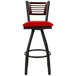 A BFM Seating metal restaurant bar stool with a mahogany back and red vinyl swivel seat.