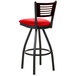 A black metal restaurant bar stool with a red vinyl swivel seat and wooden back.