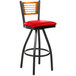 A BFM Seating black metal bar stool with a red swivel seat.