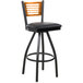 A BFM Seating Espy black metal bar stool with a wooden back and black vinyl seat.
