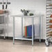 A Steelton stainless steel work table with a metal undershelf and a bowl of vegetables on it.