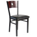A BFM Seating black metal side chair with a wooden back and black vinyl seat.