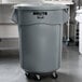 A large gray Rubbermaid trash can with wheels and a dolly.