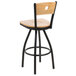 A BFM Seating black metal bar chair with a natural wood back and swivel seat.