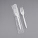 A Choice white plastic fork in plastic packaging.