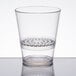 A clear plastic WNA Comet FunFusions rocks glass with a clear rim and patterned strainer.