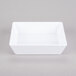 An American Metalcraft white square melamine bowl on a gray surface.
