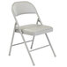 A gray National Public Seating Commercialine folding chair with a gray seat cushion.