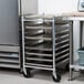 A Channel aluminum sheet pan rack holding metal trays on wheels.