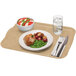 A rectangular desert tan fiberglass Cambro tray with food, a fork and knife on a napkin on a table.