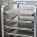 A Channel End Load Undercounter Sheet Pan Rack holding trays on a metal tray.