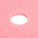 A pink Scrubble burnishing pad with a hole in the center.