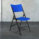 National Public Seating 604 Black Metal Folding Chair with Blue Blow Molded Plastic Back and Seat Main Thumbnail 1