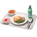 A white Cambro cafeteria tray with a plate of food, a bowl of salmon and green beans, and a glass of water.