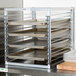 A Channel stainless steel sheet pan rack with trays on it.