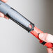 A hand holding a black and red Unger ErgoTec locking cone.