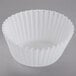 A white fluted baking cup on a white background.