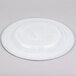 A white Charge It by Jay alabaster glass charger plate with a circular design and silver rim.