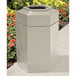 A beige hexagonal waste container with an open top.