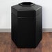 A black hexagonal Commercial Zone PolyTec trash can on a wood surface.