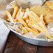American Metalcraft Natural Newspaper Print Deli Sandwich Wrap Paper in a glass bowl with french fries and chicken nuggets.