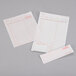 Choice 2 Part Tan and White Carbonless Guest Check with Bottom Guest Receipt on a gray surface.