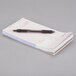 A pen on top of a stack of Choice tan and white guest receipts.