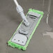 A Unger SmartColor green mop pad with a handle.