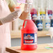 A gallon jug of Carnival King cotton candy snow cone flavoring syrup with a pump dispenser.