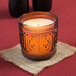 A Sterno rose flameless wax candle in a black glass holder.