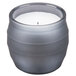 A Sterno gray wax filled glass candle lamp with a flame inside.