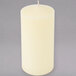 An ivory wax pillar candle on a white background.