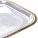 A close up of a Vollrath rectangular metal catering tray with gold trim.