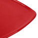 A close-up of a red GET Triangular Melamine Plate with curved edges.