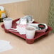 A red GET fast food tray on a table with food and a white cup with a drink in it.
