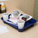 A cobalt blue polypropylene tray with a white cup and a plate of food on it.