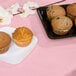 A plate of muffins covered by a Classic Pink Tissue / Poly Table Cover.