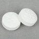 Two white Medique APAP acetaminophen tablets with numbers on them.