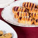 A Tuscan Flare oval melamine platter with pastries and cookies on a table.
