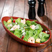 An Osslo melamine bowl filled with shrimp and spinach salad on a table.