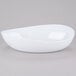 A white oval bowl on a gray surface.